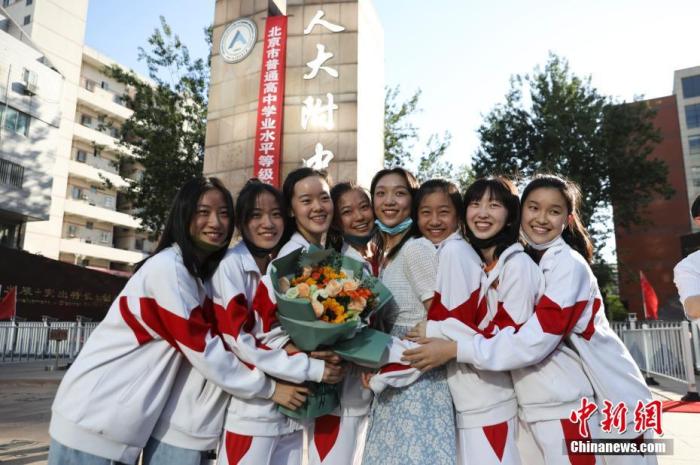 资料图:6月10日,在北京人大附中高考考点外,考生们相拥拍照留念。当日,北京市2021年高考结束。 <a target='_blank' href='http://www.chinanews.com/'>中新社</a>记者 赵隽 摄 点击进入下一页