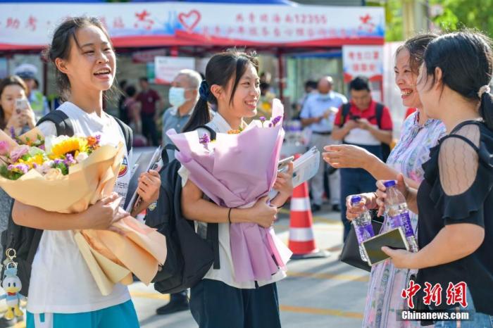 资料图:6月10日,海南省海口市海南中学考点外,家长为刚刚走出考场的考生送上鲜花。当日,海南省2021年高考结束 。 <a target='_blank' href='http://www.chinanews.com/'>中新社</a>记者 骆云飞 摄 点击进入下一页